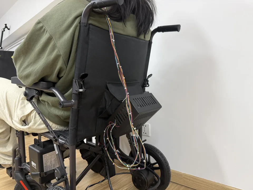 Rear view of the wheelchair showing the electronics enclosure and wiring from the glasses.